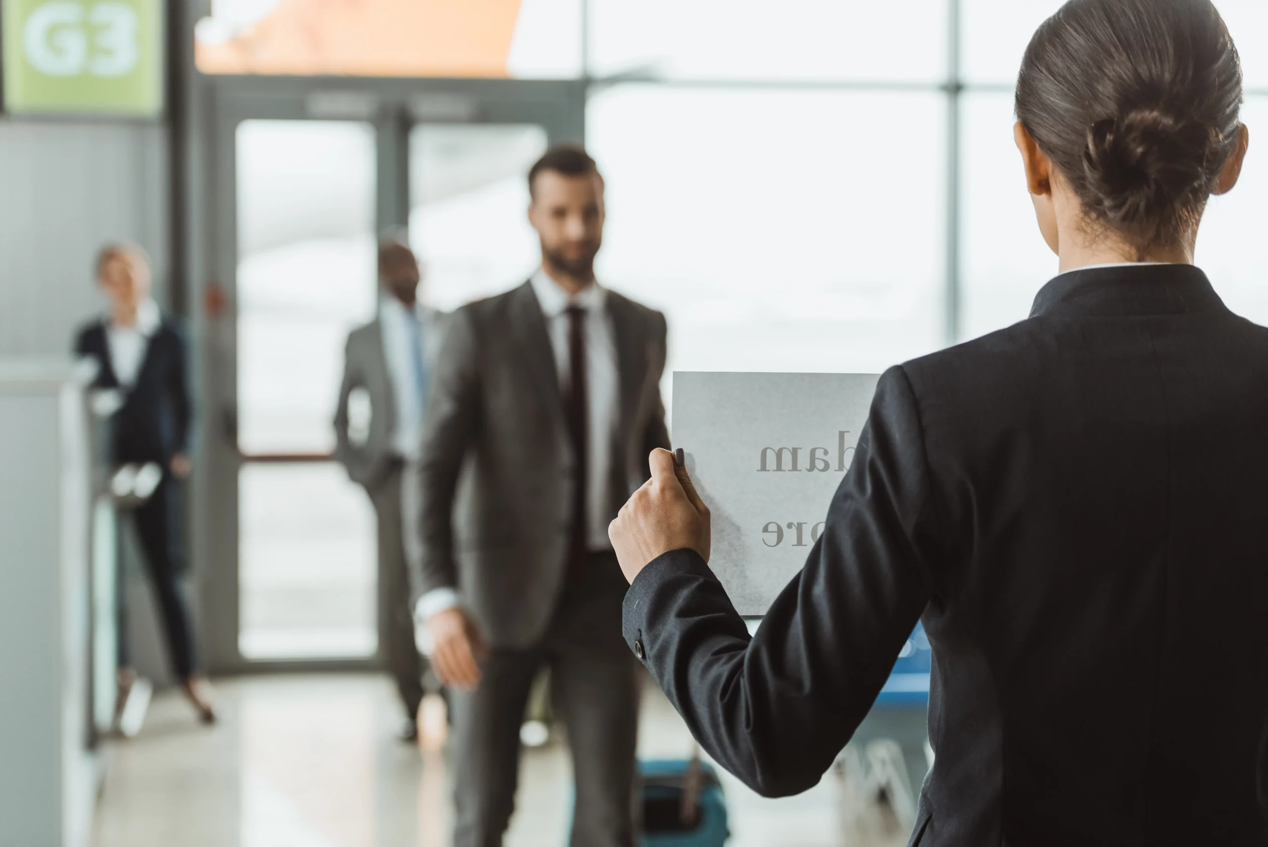 Airport chauffeur holding a pickup card